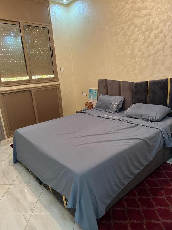 1 dormitorio con 1 cama grande con sábanas azules en planets house, en Deroua