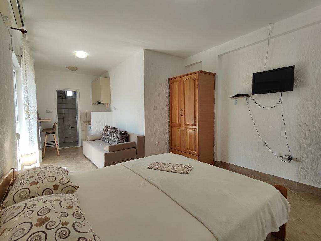 a bedroom with a bed and a tv on a wall at MM Apartments in Budva