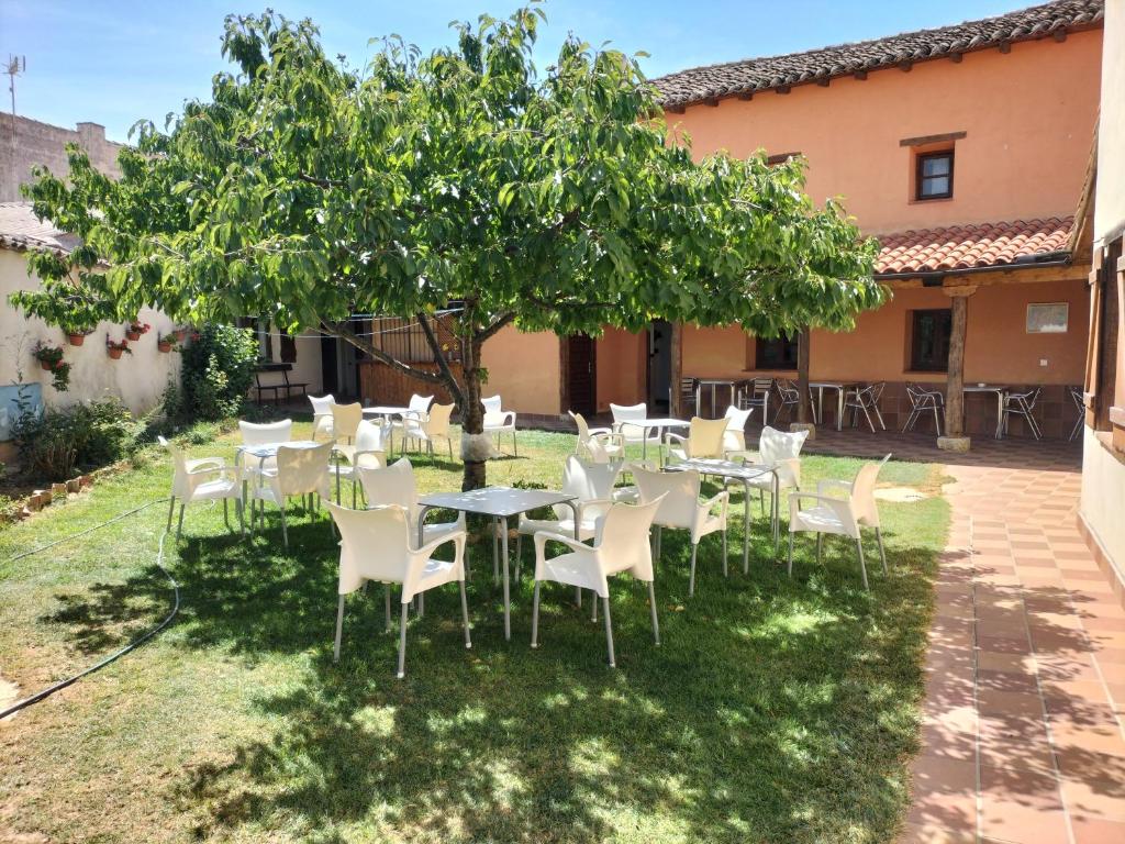 um grupo de mesas e cadeiras debaixo de uma árvore em DON CAMINO, (Casa Federico) em Villalcázar de Sirga