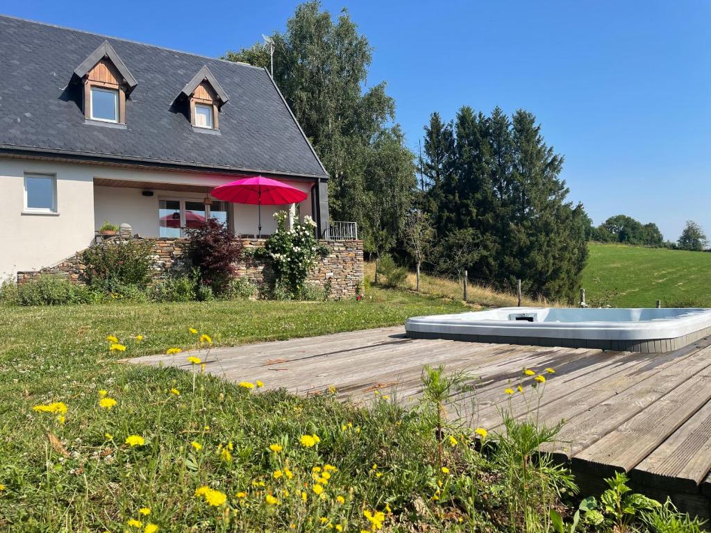 une maison avec un bateau sur une terrasse en bois dans l'établissement Maison en pleine nature avec spa, à Vezels-Roussy