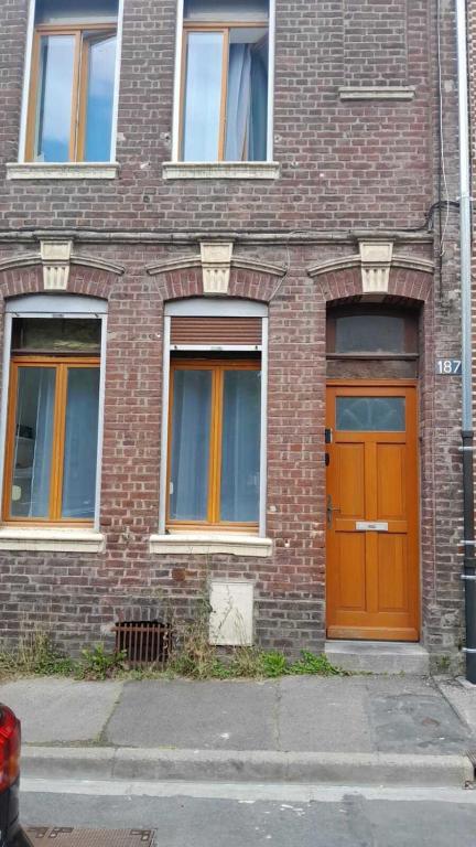 a brick building with a orange door on it at Mimosa* Proche Centre-Ville et CHU*Parking in Amiens