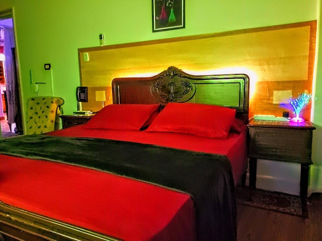 - une chambre avec un lit rouge et une tête de lit en bois dans l'établissement Fayrouzat Almndra near the sea with garden view, à Alexandrie
