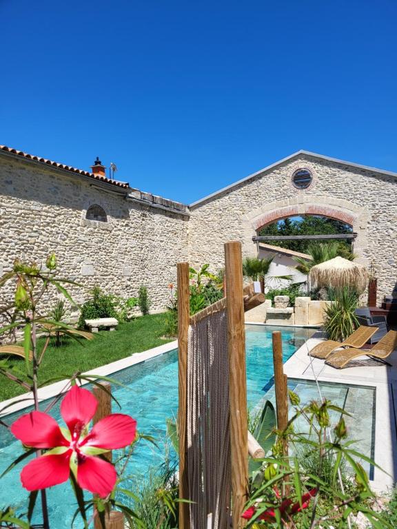een huis met een zwembad met een rode bloem bij Le Mas de Fanfan in Le Cailar