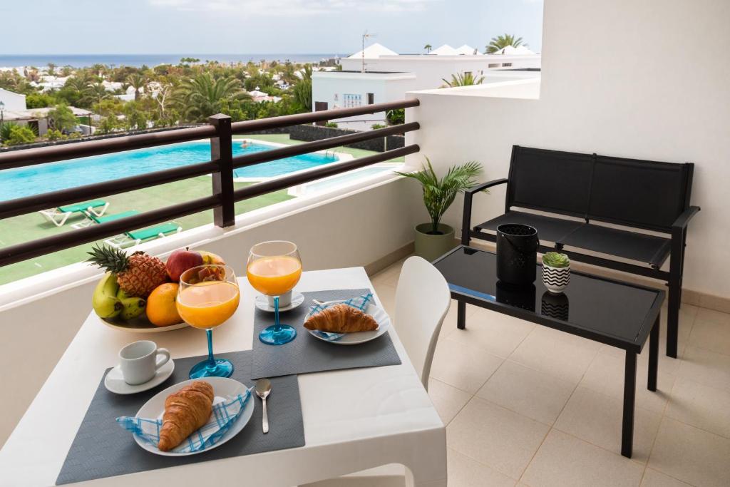 - une table avec des fruits et des jus de fruits sur un balcon dans l'établissement Tyler's House Ocean View, à Costa Teguise