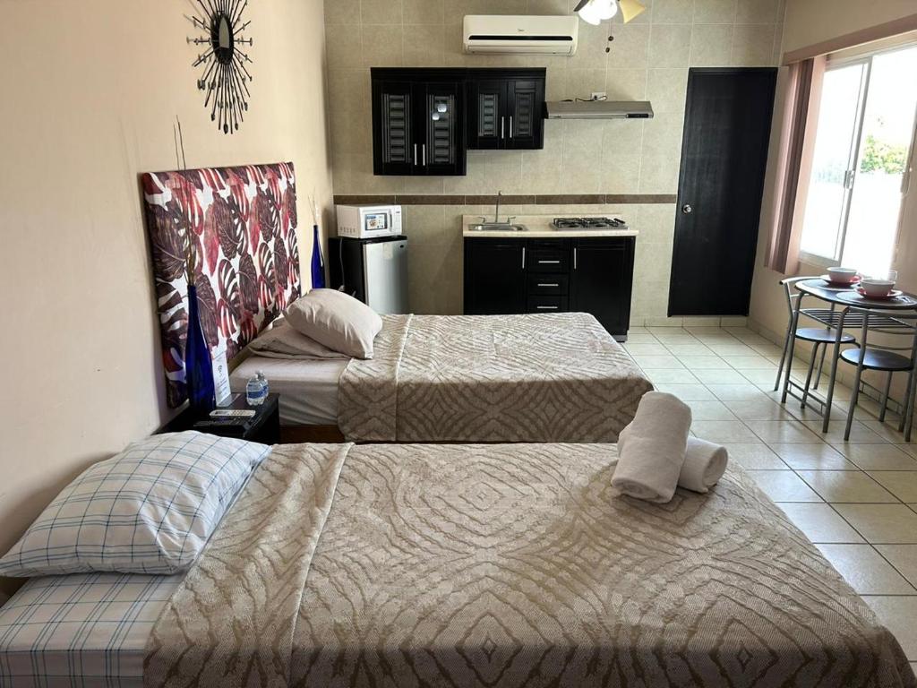 a hotel room with two beds and a kitchen at Habitaciones Amuebladas Castillo98 in Veracruz