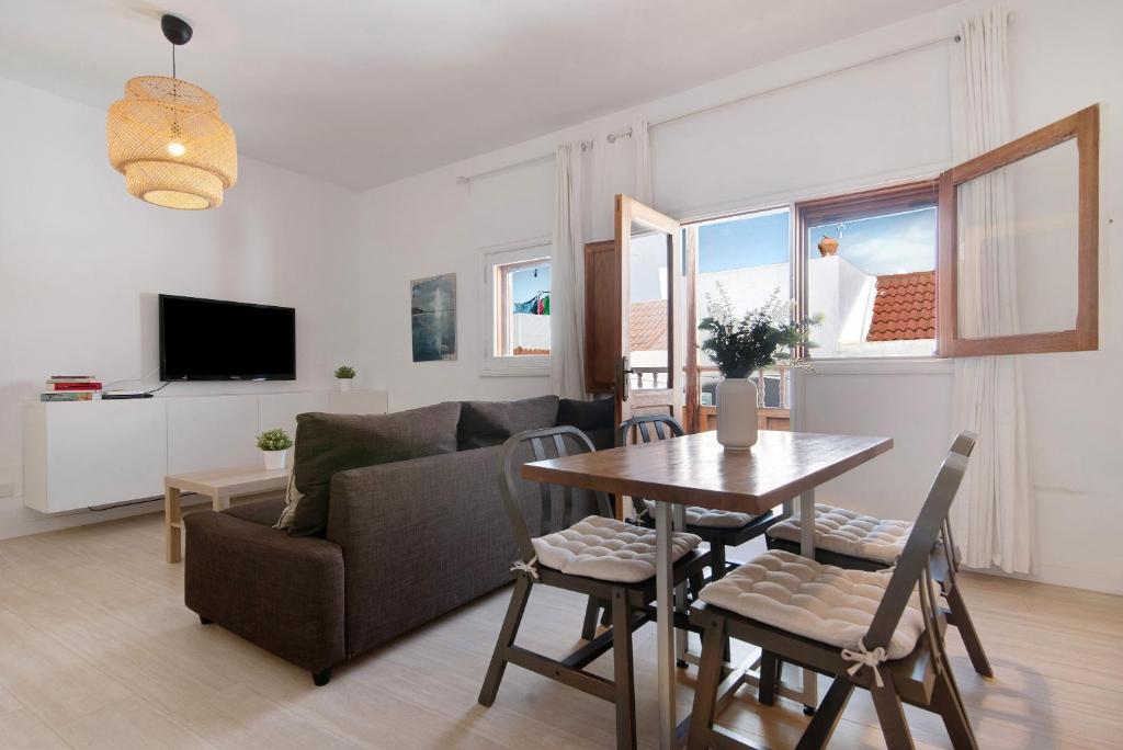 een woonkamer met een tafel en een bank bij Balcon de Porteria in Telde