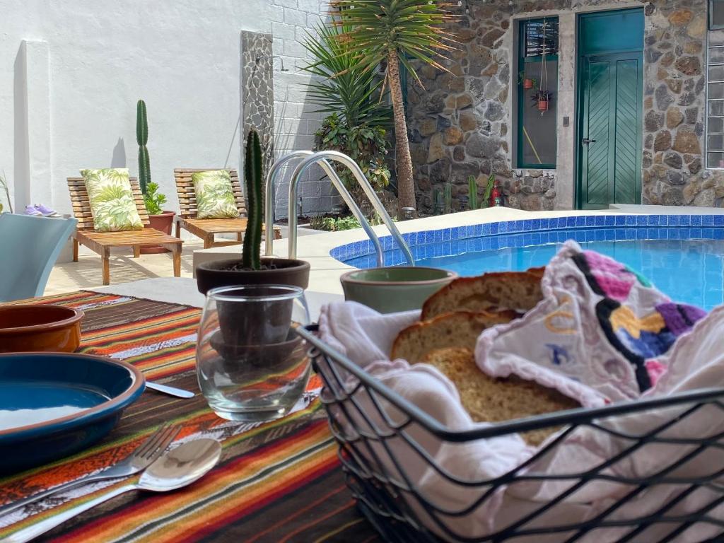 einen Tisch mit einem Korb Brot auf dem Tisch in der Unterkunft Hostal Pimampiro in Puerto Baquerizo Moreno