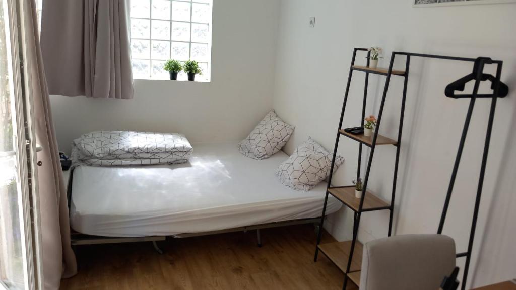 ein kleines Bett in einem Zimmer mit Fenster in der Unterkunft Lumineux studio neuf au calme in Villejuif