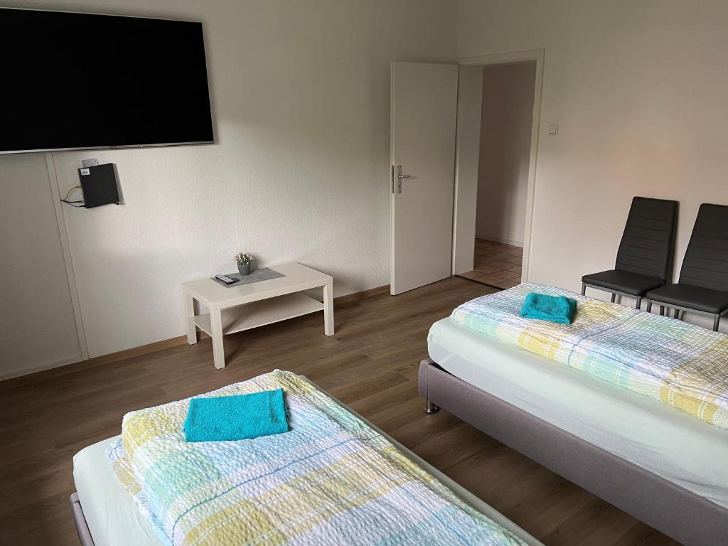 a room with two beds and a flat screen tv at Esslingen am Neckar Weilstr.47 in Esslingen