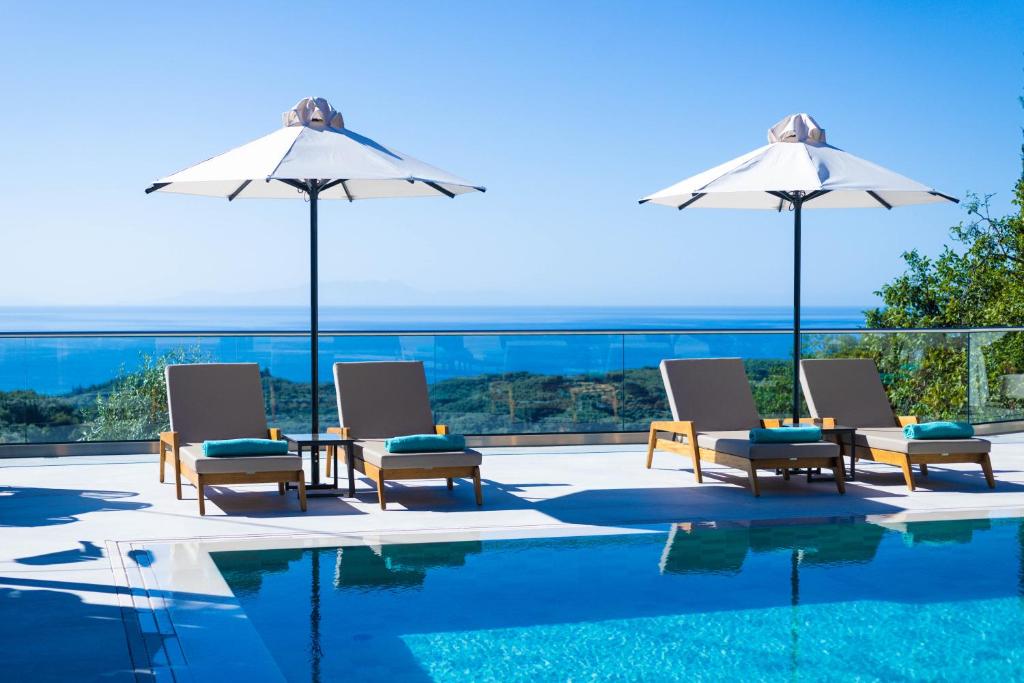 - un groupe de chaises longues et de parasols à côté de la piscine dans l'établissement My Suite Boutique Hotel, à Parga