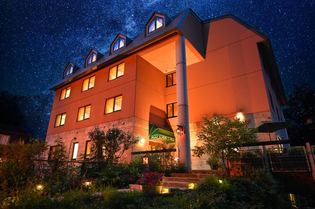 un edificio naranja por la noche con un cielo estrellado en Hotel Stelle Belle en Hakuba