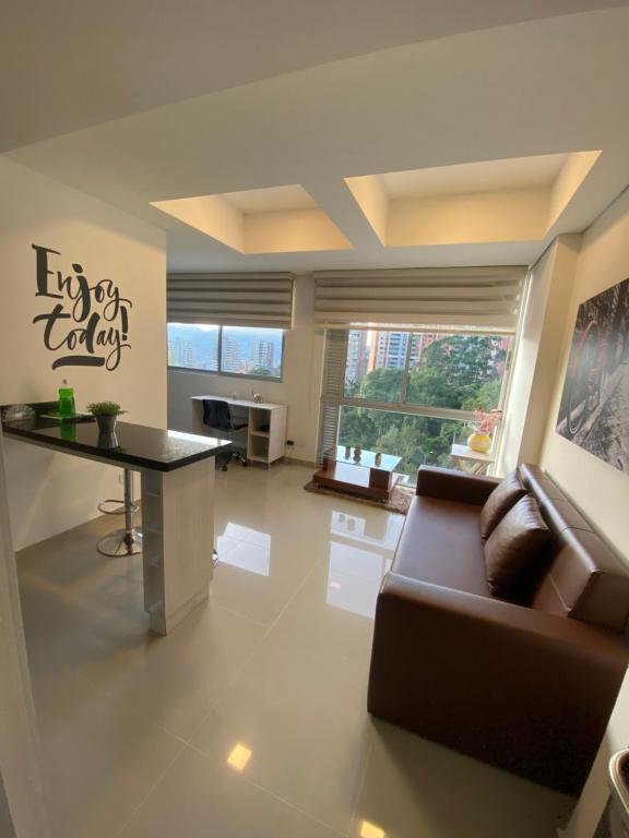 un salon avec un canapé et une table dans l'établissement Apartasuite moderna - en el corazón del poblado medellín, à Medellín