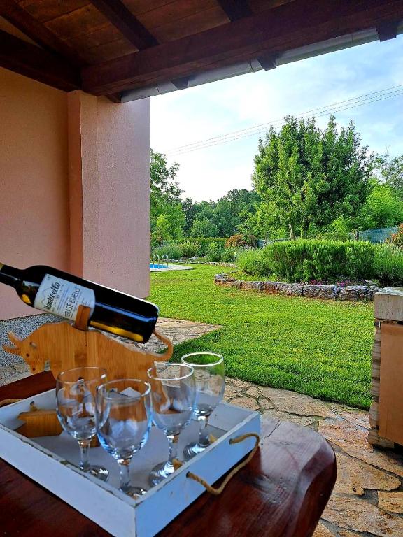 a bottle of wine is being poured into wine glasses at Villa Malini in Grožnjan