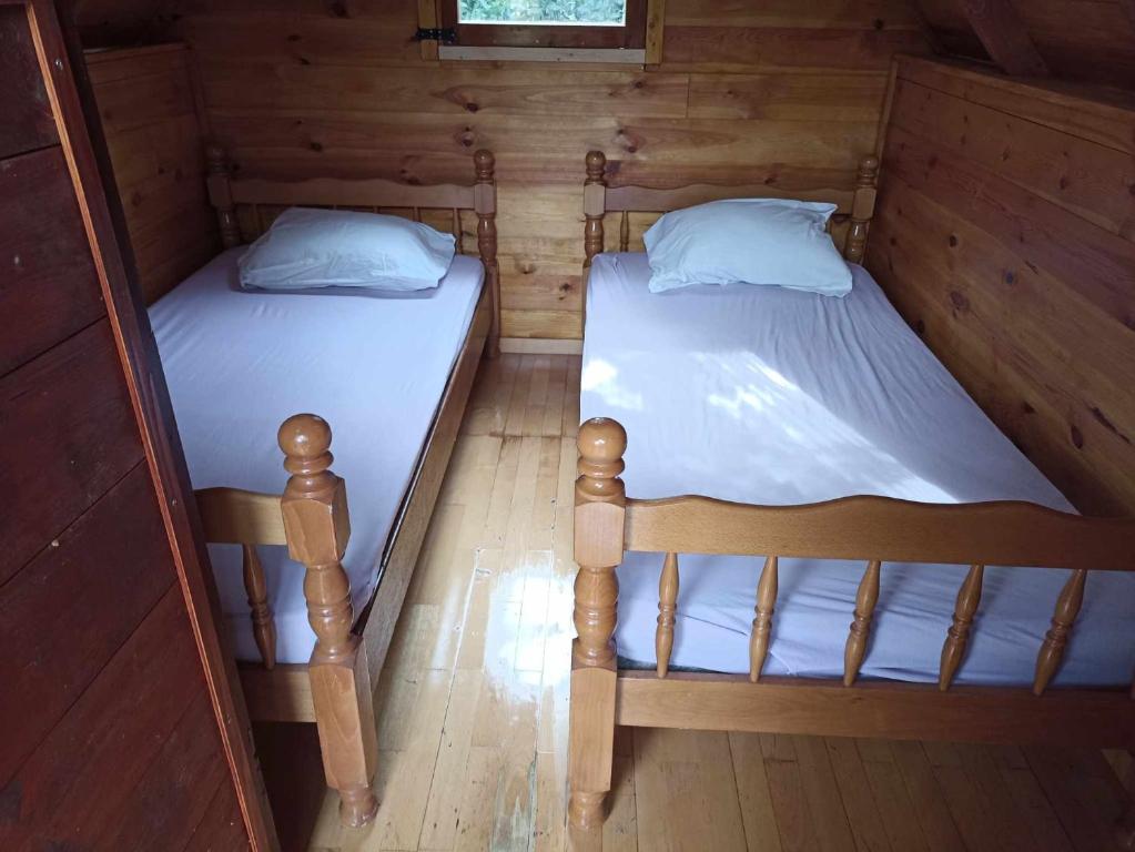 赫爾採格諾維的住宿－Kamp Seosko domaćinstvo Radman - Bungalov，小屋设有2张单人床和木墙
