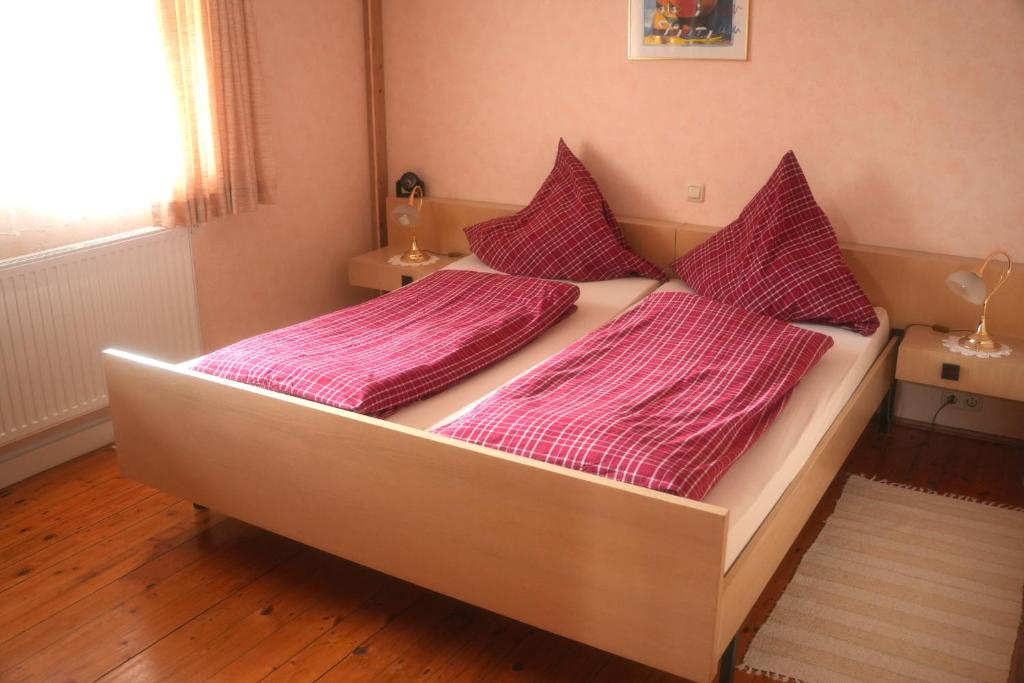 ein großes Bett mit rosa Bettwäsche im Schlafzimmer in der Unterkunft Ferienwohnung Vorndran in Bischofsheim an der Rhön