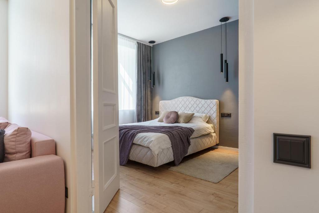 een slaapkamer met een bed waar een persoon op ligt bij Centra apartamenti in Liepāja