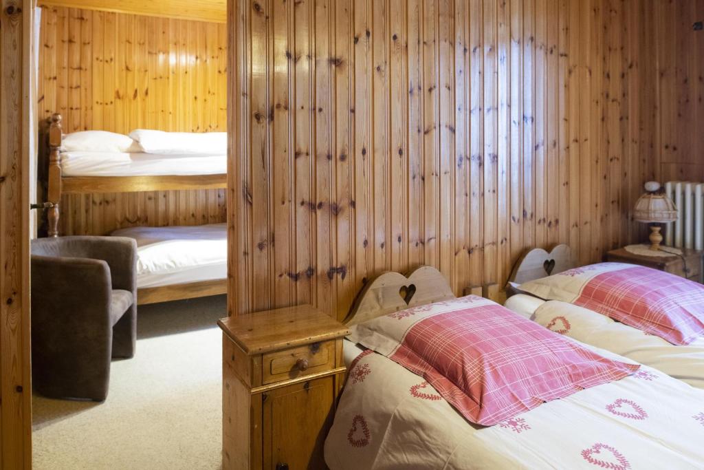 a bedroom with two beds in a room with wooden walls at Aiguille de La Tza in Arolla