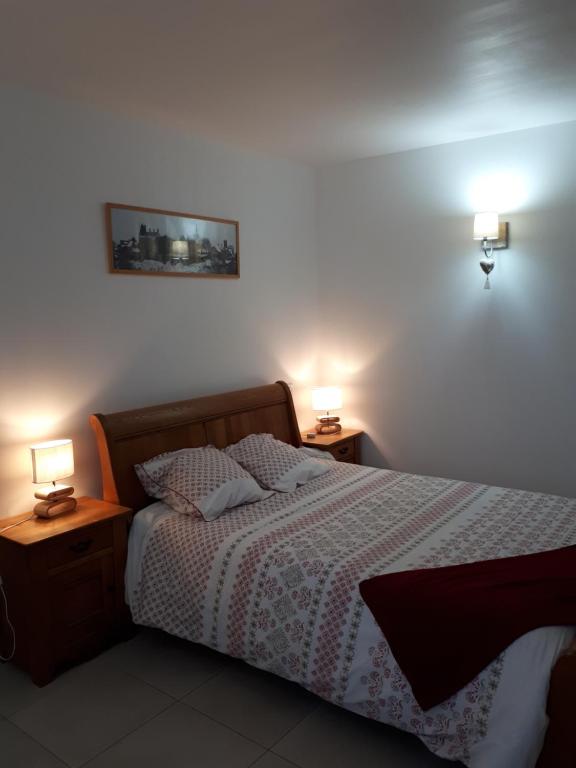 una camera da letto con un letto con due lampade su due tavoli di chez Zabou chambre Suzannaise a Sainte-Suzanne