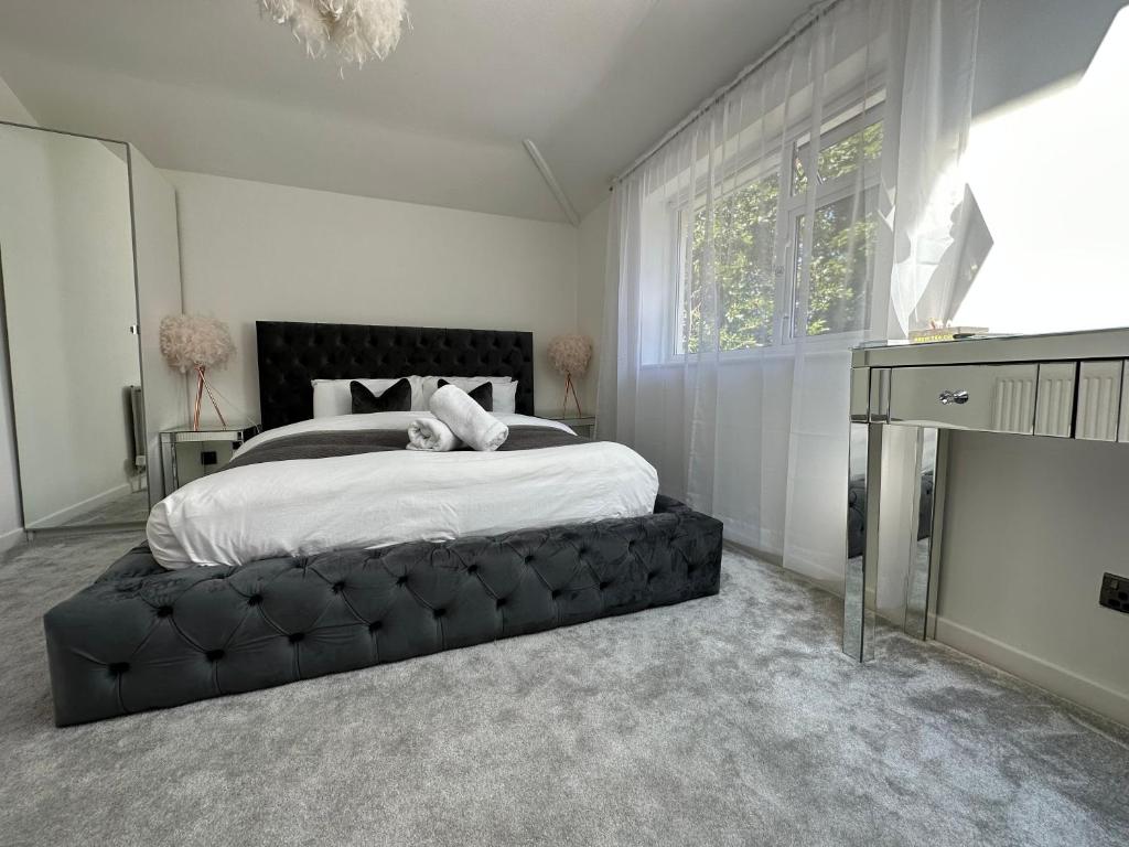 um quarto com uma cama grande e um repousa-pés preto em 5 min from the beach ,parking in Guest House em Bournemouth