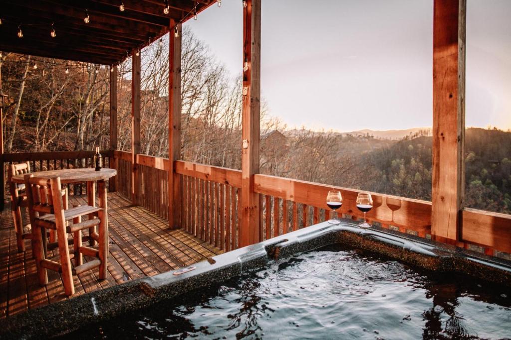 a hot tub on the deck of a cabin at Expansive Mountain Views, Theater, Games, Hot Tub, Relaxing porches in Sevierville