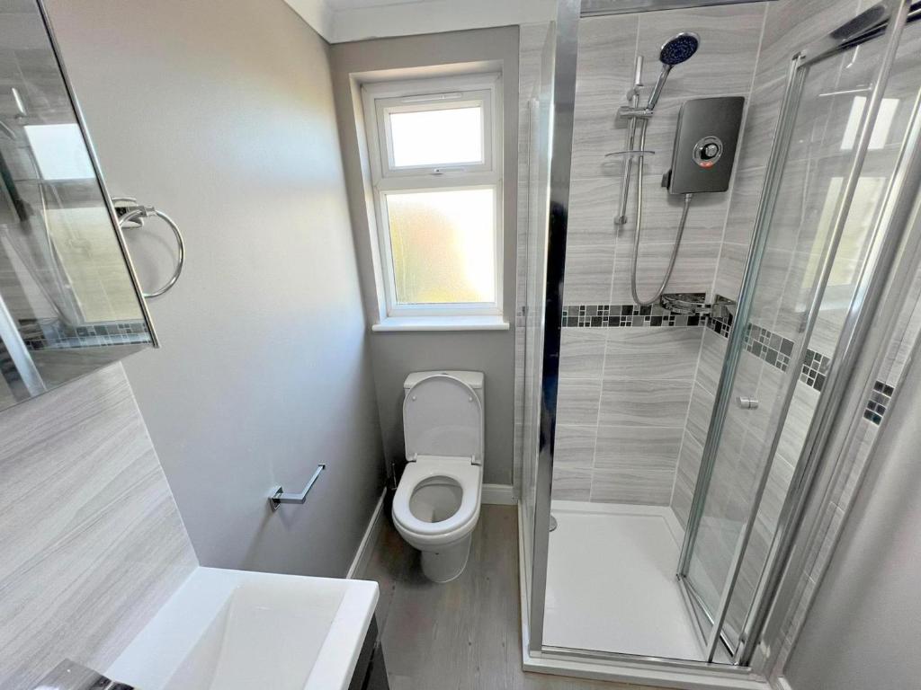 a small bathroom with a toilet and a shower at New Florence Rooms in Mitcham