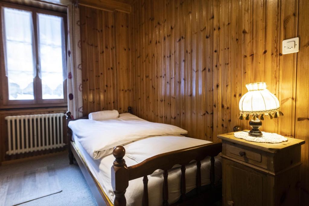 a bedroom with a bed and a lamp on a table at Aiguille de La Tza in Arolla