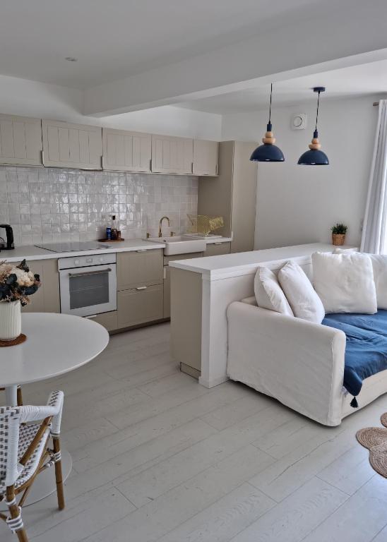 Il comprend un salon blanc avec un canapé et une cuisine. dans l'établissement Victoire Saphir 203 climatisé hôtel de ville, à Saint-Dizier