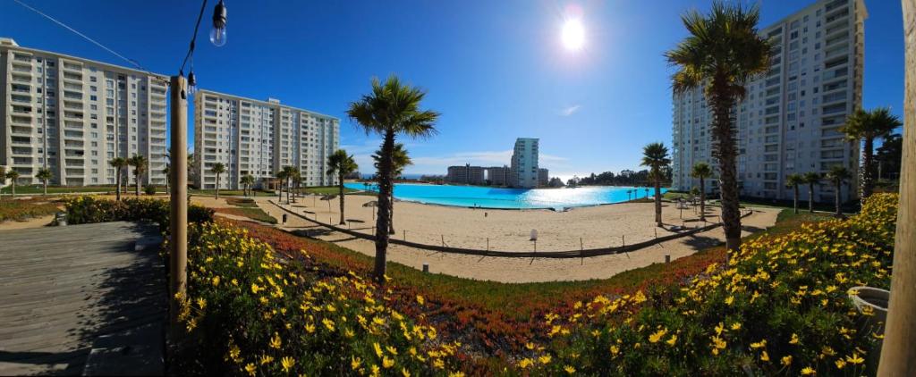 una gran piscina en un parque con palmeras y edificios en Laguna Bahía Algarrobo., en Algarrobo