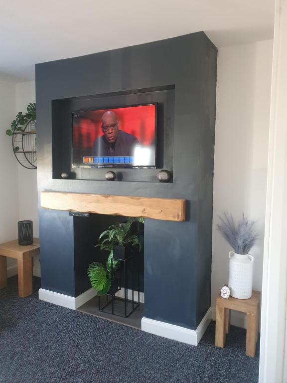 a fireplace with a television in a living room at The Airfield Happy Apartment 