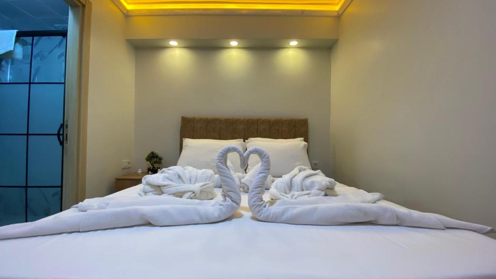 due asciugamani a forma di cigno sono stesi su un letto di Stone house apart hotel a Arnavutköy