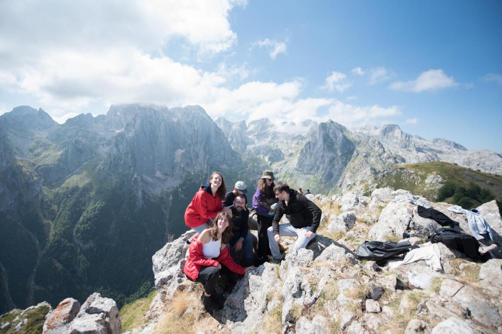 a group of people sitting on top of a mountain at 1971 apartments in Gusinje