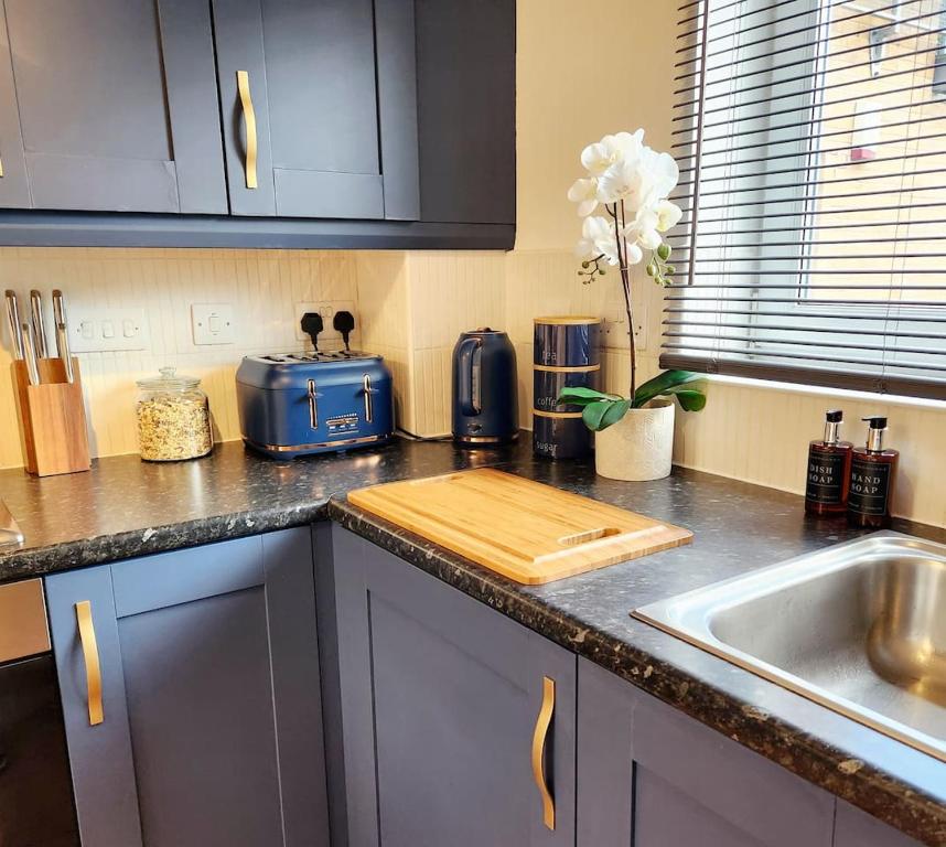 a kitchen counter with a cutting board next to a sink at Beeches House - Stylish Detached house with private garden located near city centre in Sheffield