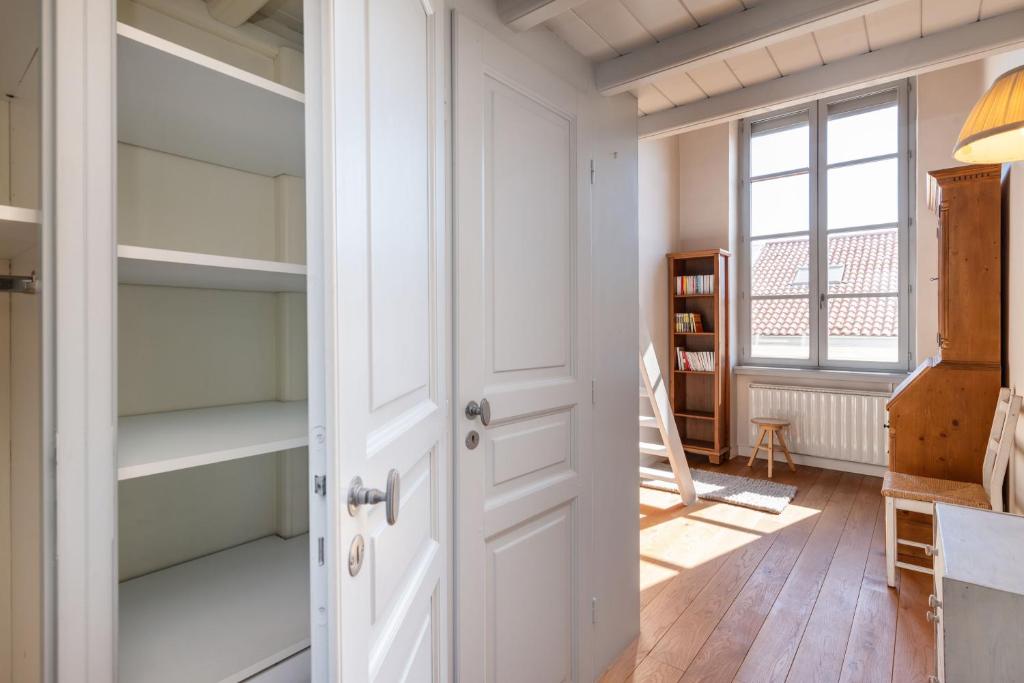 a room with white shelves and a door at Le Cocon Pacôme Les Autres in Lyon