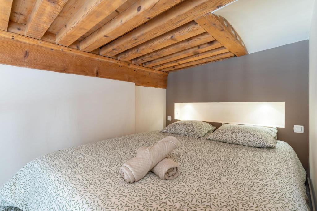 a bedroom with a large bed with a wooden ceiling at Le Cocon Pacôme Les Autres in Lyon