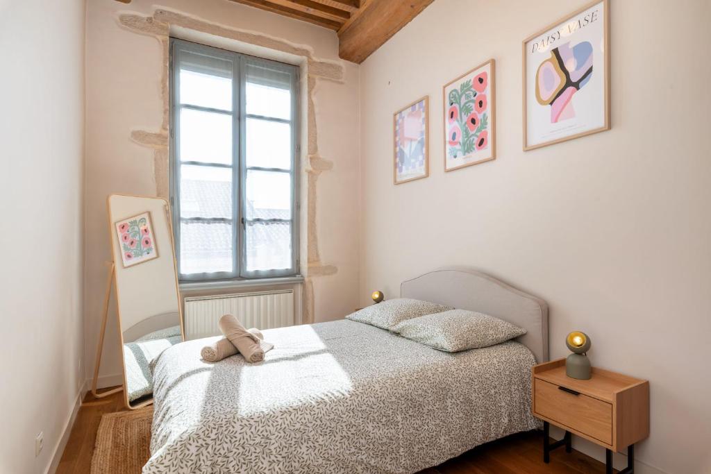 a bedroom with a bed with a teddy bear on it at Le Cocon Pacôme Les Autres in Lyon