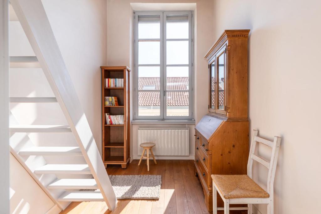 a room with a staircase and a book shelf at Le Cocon Pacôme Les Autres in Lyon