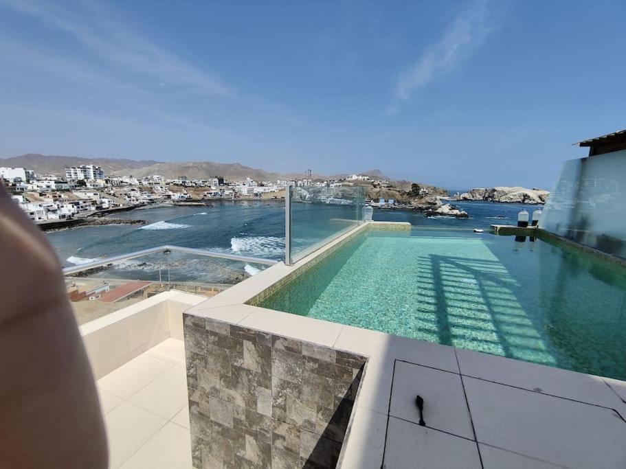 una piscina en la parte superior de un edificio con vistas al agua en Excelente departamento frente al mar., en San Bartolo