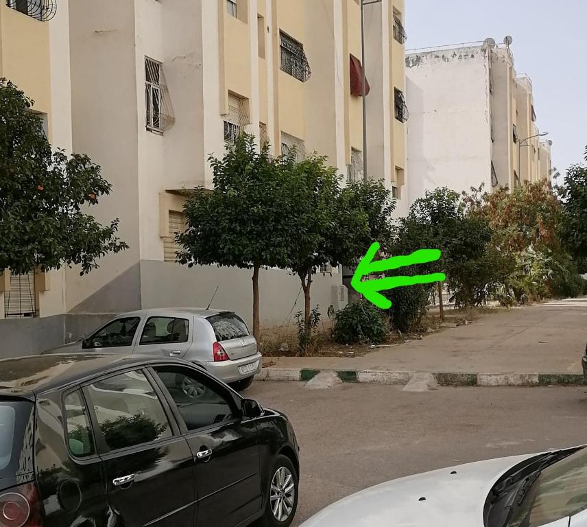 a green arrow pointing to a car parked next to a building at Appartement Fès in Fez