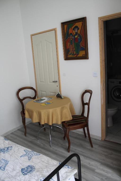 a room with a table and a chair and a mirror at Castellum Apartman in Keszthely