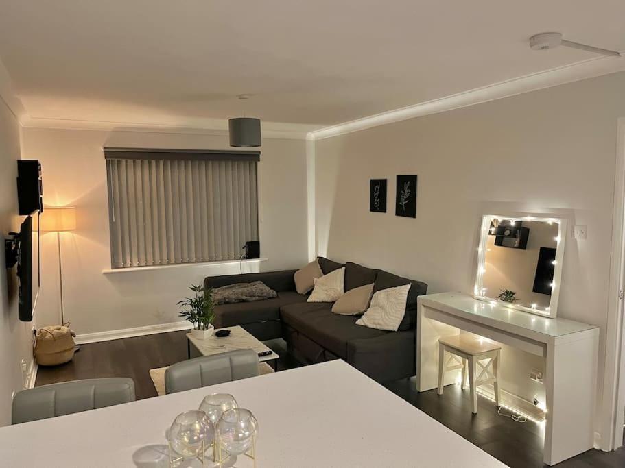 ein Wohnzimmer mit einem Sofa und einem Tisch in der Unterkunft Newly Refurbished Apartment with private parking in Southampton