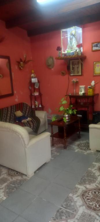 a living room with a white couch and a red wall at El cerrito in Cerrillos