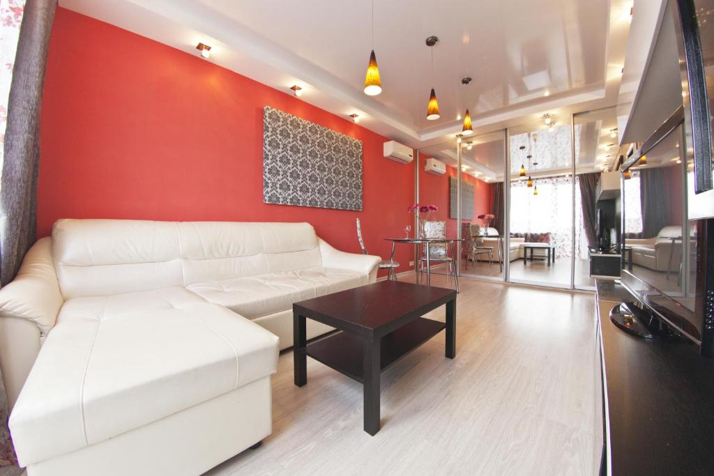 モスクワにあるLakshmi Apartments Dinamoの白いソファと赤い壁のリビングルーム