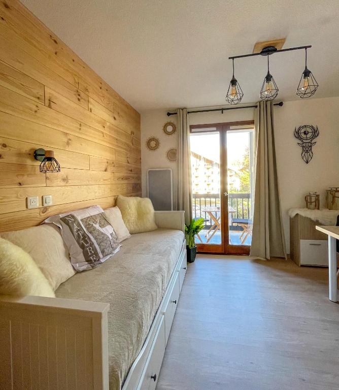 - une chambre avec un lit et un mur en bois dans l'établissement Chalereux studio a la montagne, à Auron