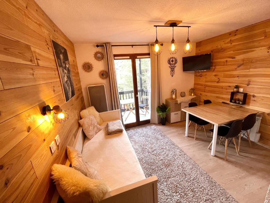 a living room with a couch and a table at Chalereux studio a la montagne in Auron