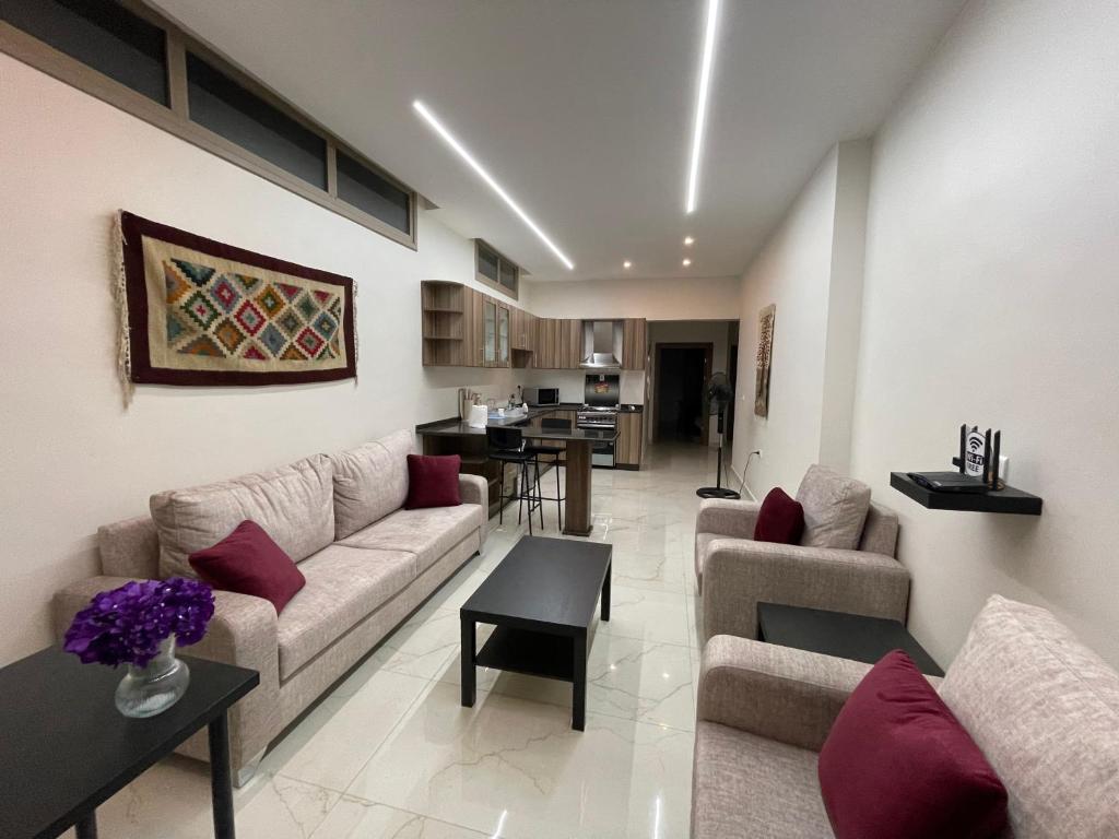 a living room with two couches and a kitchen at Jasmine flower hostel in Madaba