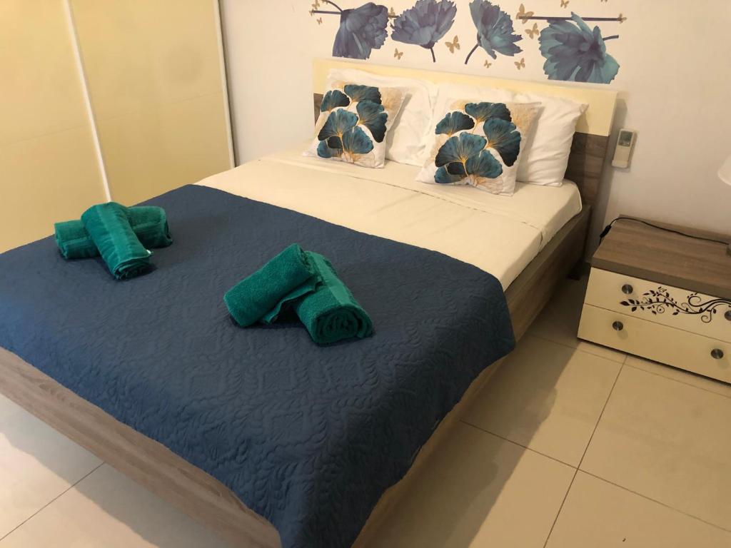 - une chambre avec un lit doté de draps et d'oreillers verts dans l'établissement Camera centrale a pochi passi da Paceville e San Giuliano, à Is-Swieqi
