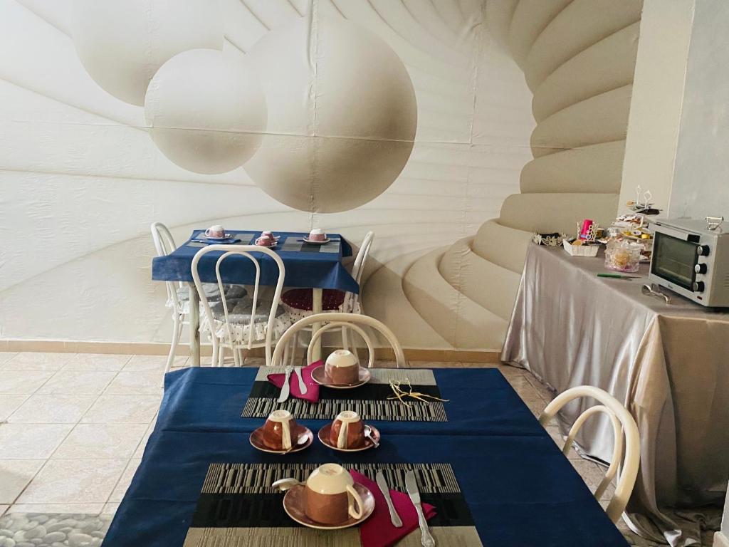オルゴーゾロにあるBed&Breakfast SaTurreの青いテーブルクロスと帽子付きのテーブル