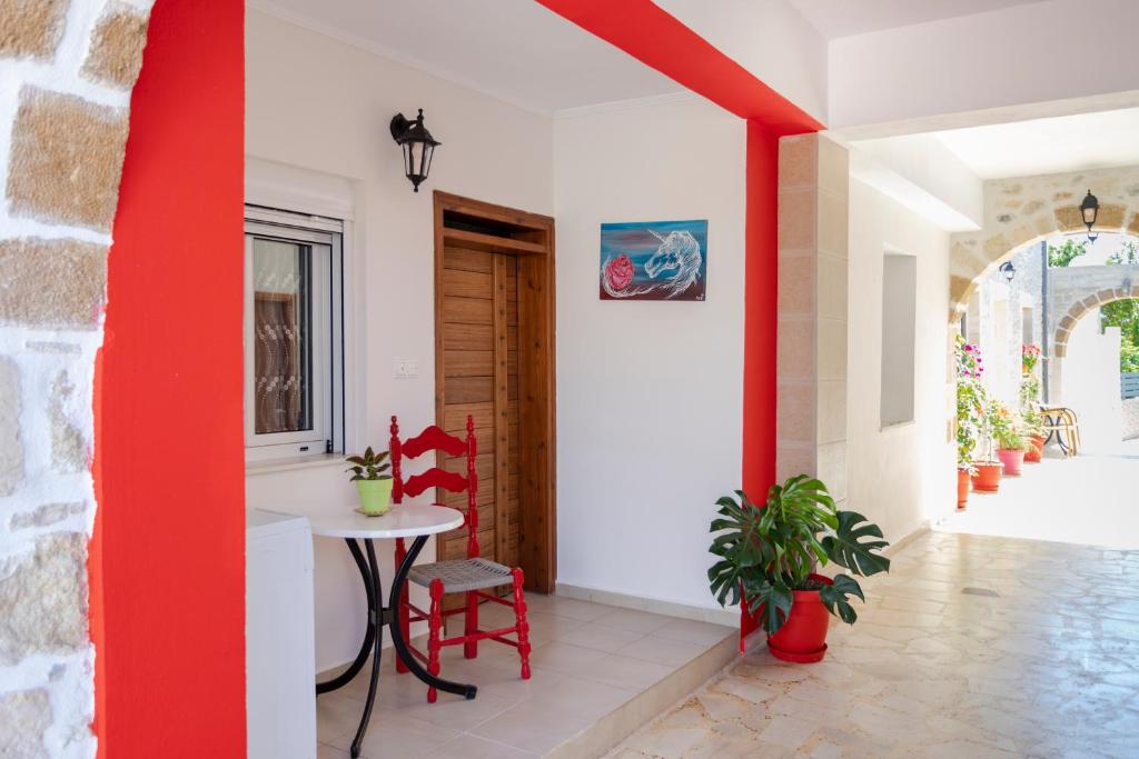 a room with a table and chairs and a red wall at Villa Vojka Naile in Pigi