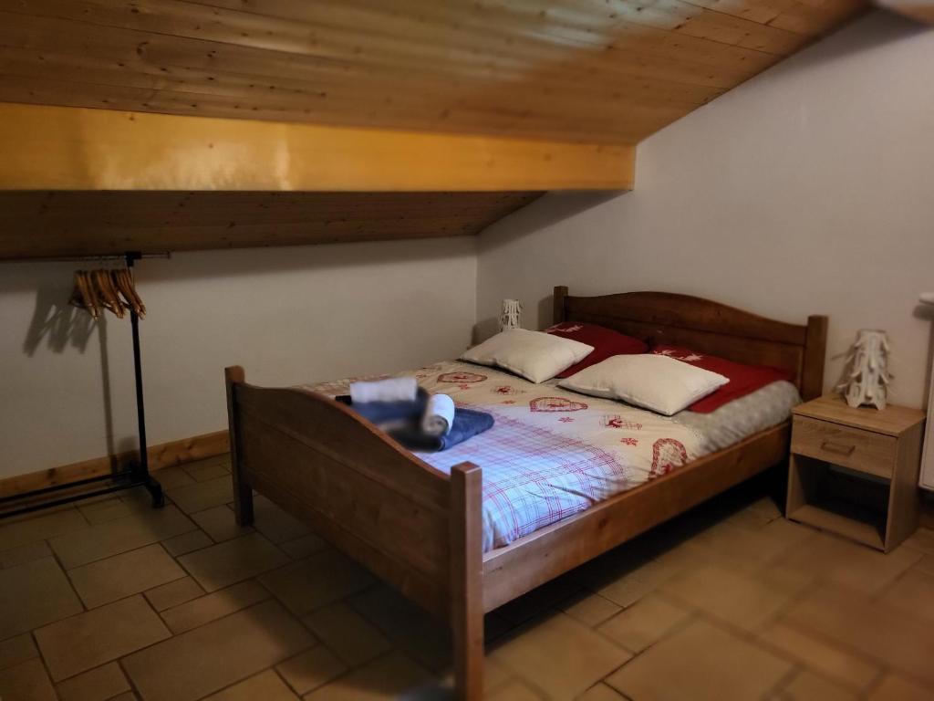 a bedroom with a bed in a room with a wooden ceiling at La petite Anfiane in Le Grand-Bornand