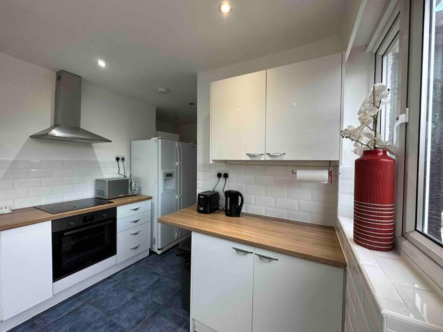 a kitchen with white cabinets and a white refrigerator at Dallas House - Easy links to LHR and London in Hayes
